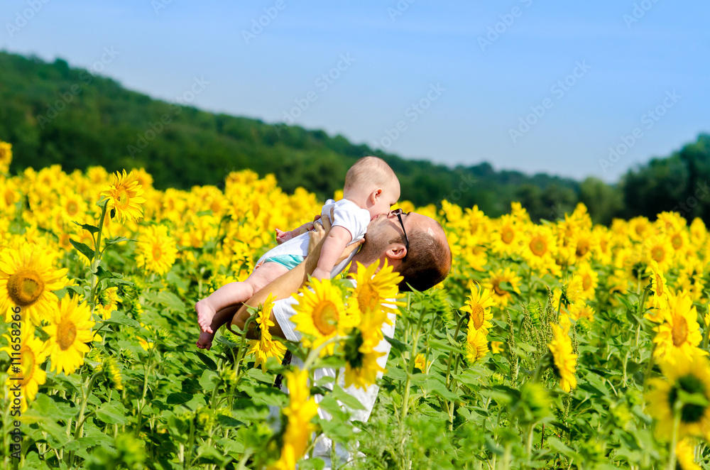 Fototapeta premium Father with son on the sunflower field