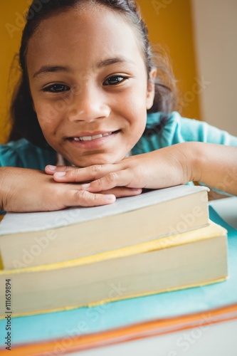 Girl leaning her head on pile of books