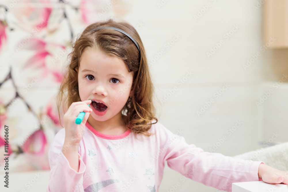 Little girl in pink pyjamas in bathroom brushing teeth Little girl in pink pyjamas in bathroom brushing teeth