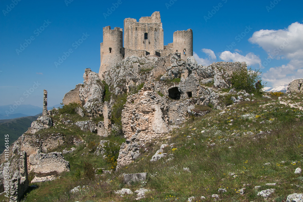Old castle in the sky. Panoramic view of Rocca Calascio with wild flowers in Abruzzo.