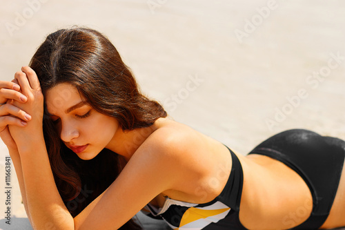 Portrait of a sensual young lady having tanning on the beach