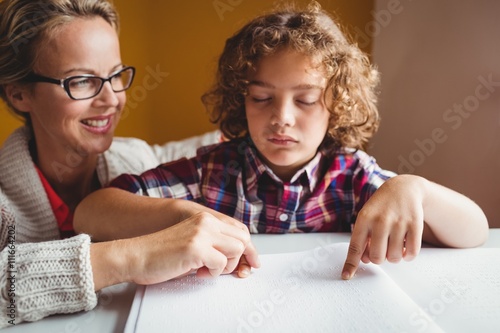 Valokuvatapetti Boy using braille to read