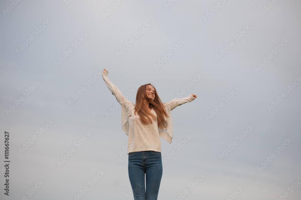 woman with open arms in the sky background at the morning woman with open arms in the sky background at the morning