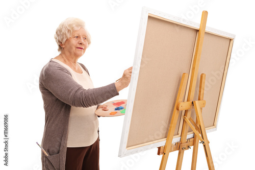 Senior woman painting on a canvas