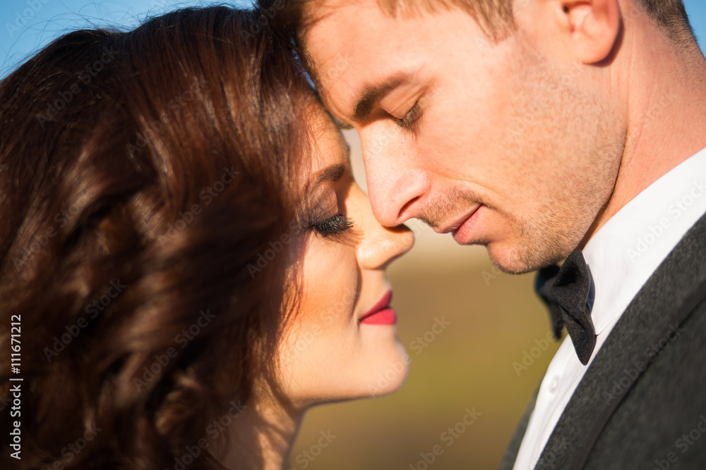 Fototapeta premium luxury stylish young bride and groom on the background spring sunny green forest