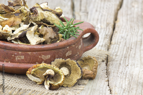 dried mushrooms in a bowl on wooden background