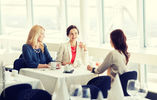 women drinking coffee and talking at restaurant
