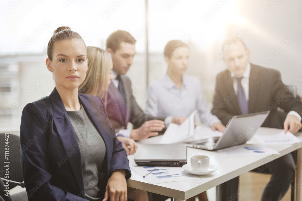 businesswoman in office with team on the back