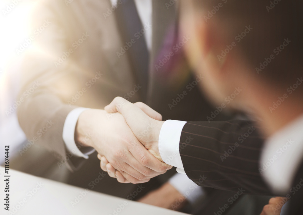 two businessmen shaking hands in office two businessmen shaking hands in office