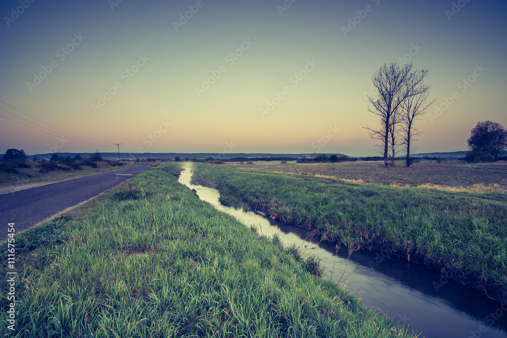 Obraz premium Krajobraz wiejski. Wschód słońca nad łąkami