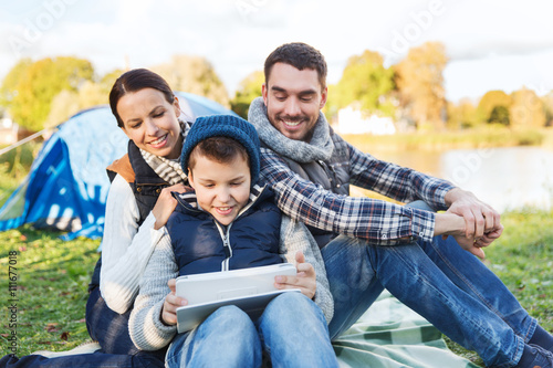 happy family with tablet pc and tent at camp site