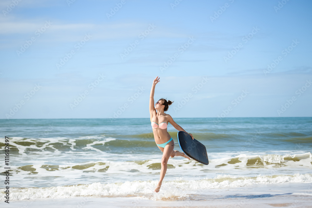 Beautiful surfer young lady on the beach with bodyboarding, ready for fun