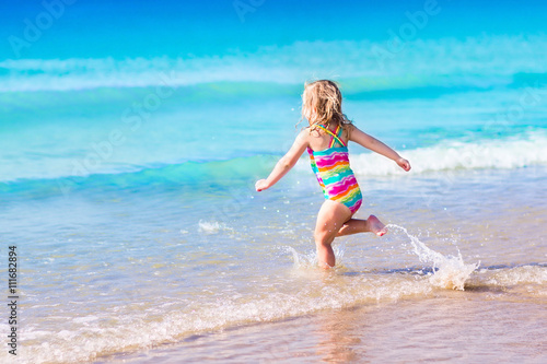 Little girl playing on tropical beach