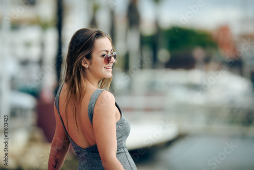 Outdoor portrait of sexy pretty woman standing on marina background