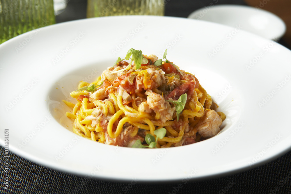 Fresh spaghetti with white fish ragout, capers and orange zest