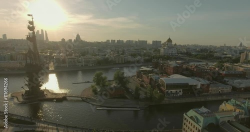 Aerial view of Peter the Great Statue on a summer spring day at sunset. Crowds of people walking along the park near river.  