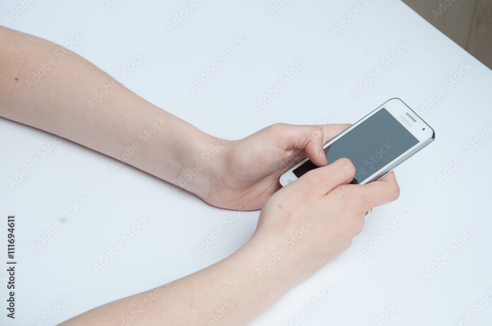 Girl holding a white smartphone. White background Girl holding a white smartphone. White background