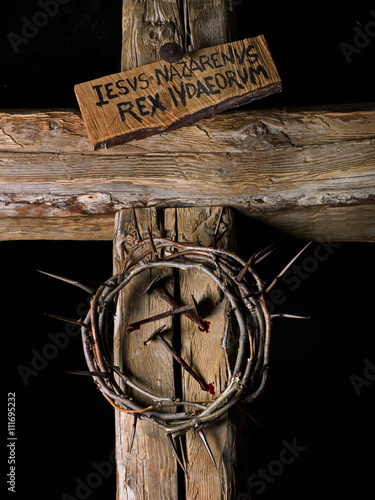 Crown of thorns and nails of Christ with blood on wooden cross