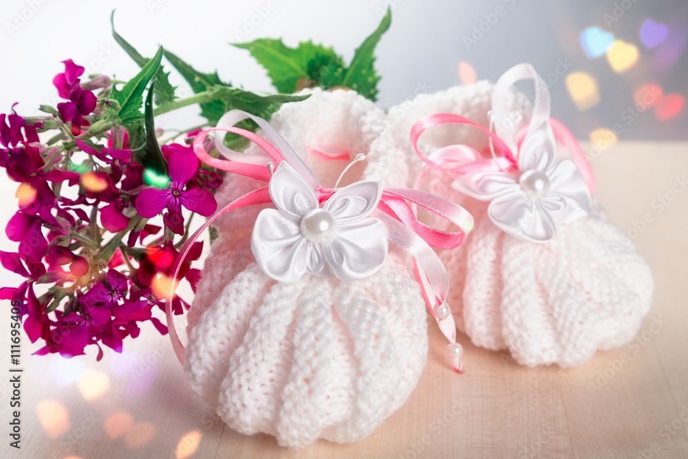 Children's shoes standing on a windowsill with a flower Children's shoes standing on a windowsill with a flower