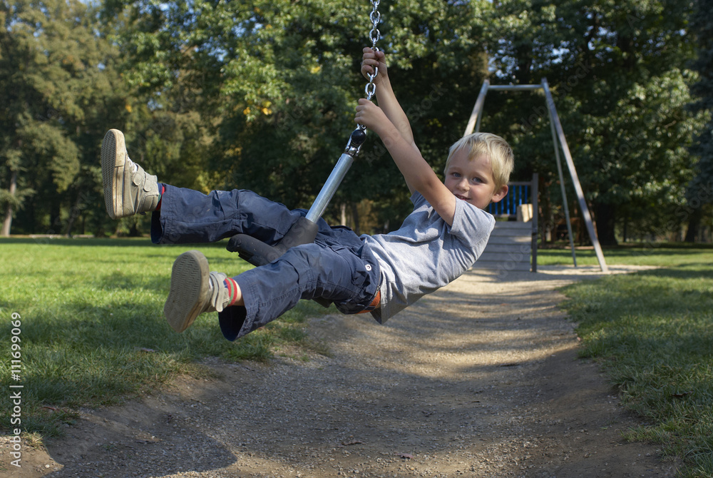 Cute child, boy, rides on Flying Fox play equipment in a children's playground, summertime Cute child, boy, rides on Flying Fox play equipment in a children's playground, summertime