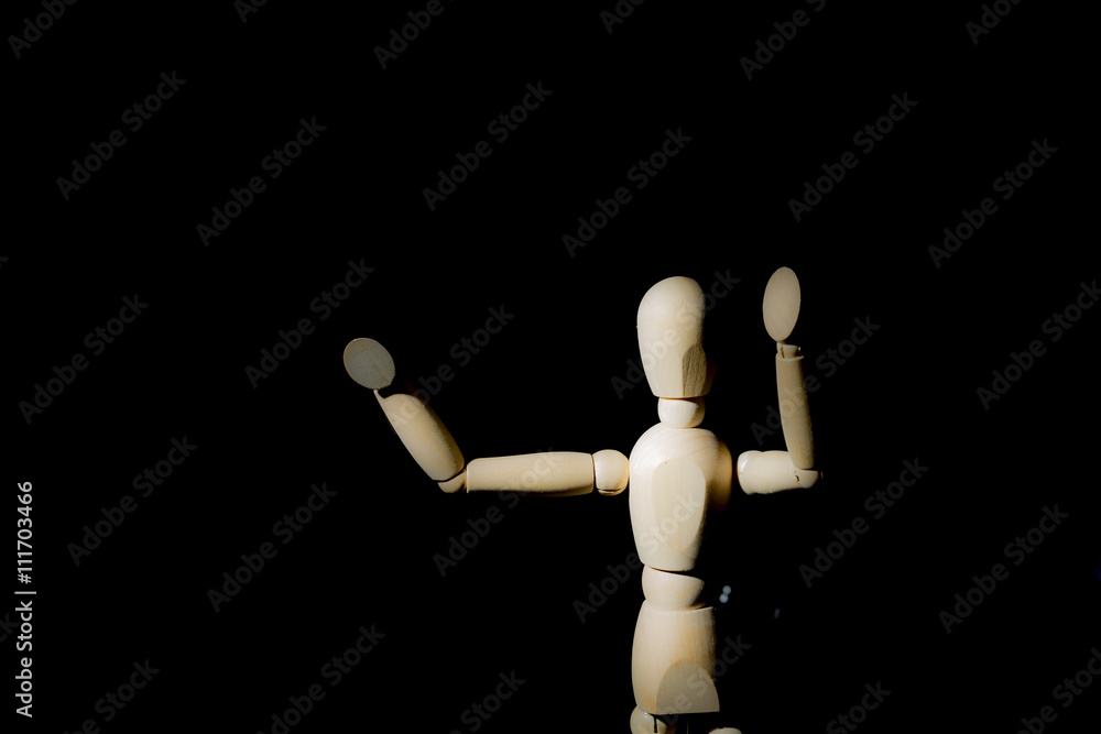 Wooden dummy with open high arms isolated on a solid black background Wooden dummy with open high arms isolated on a solid black background