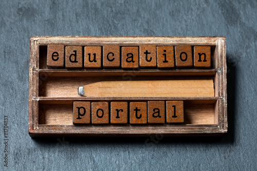 Education portal conceptual image. Vintage blocks with text, retro style pencil in wooden box. Gray stone background, macro photo