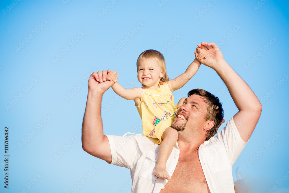 Portrait of happy man holding his little daughter on neck on the background of sky Portrait of happy man holding his little daughter on neck on the background of sky