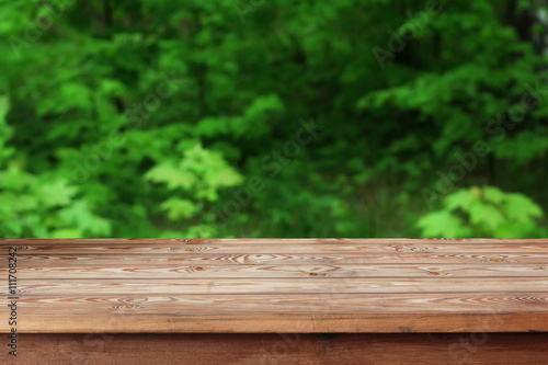 Empty wooden table over bokeh background.