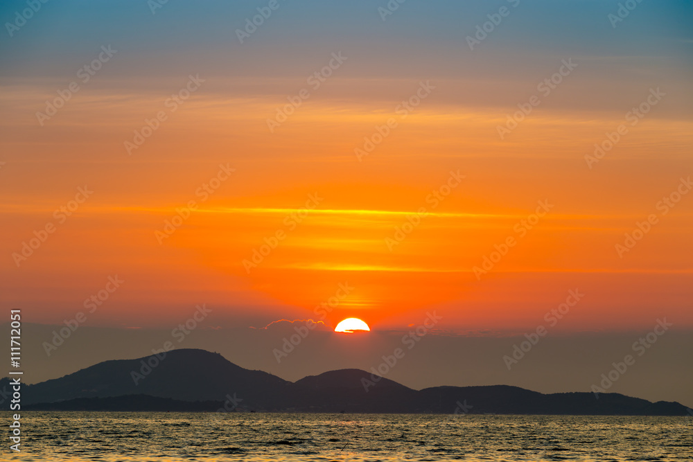 Naklejka premium Sea landscape with sunset behind mountain and sea