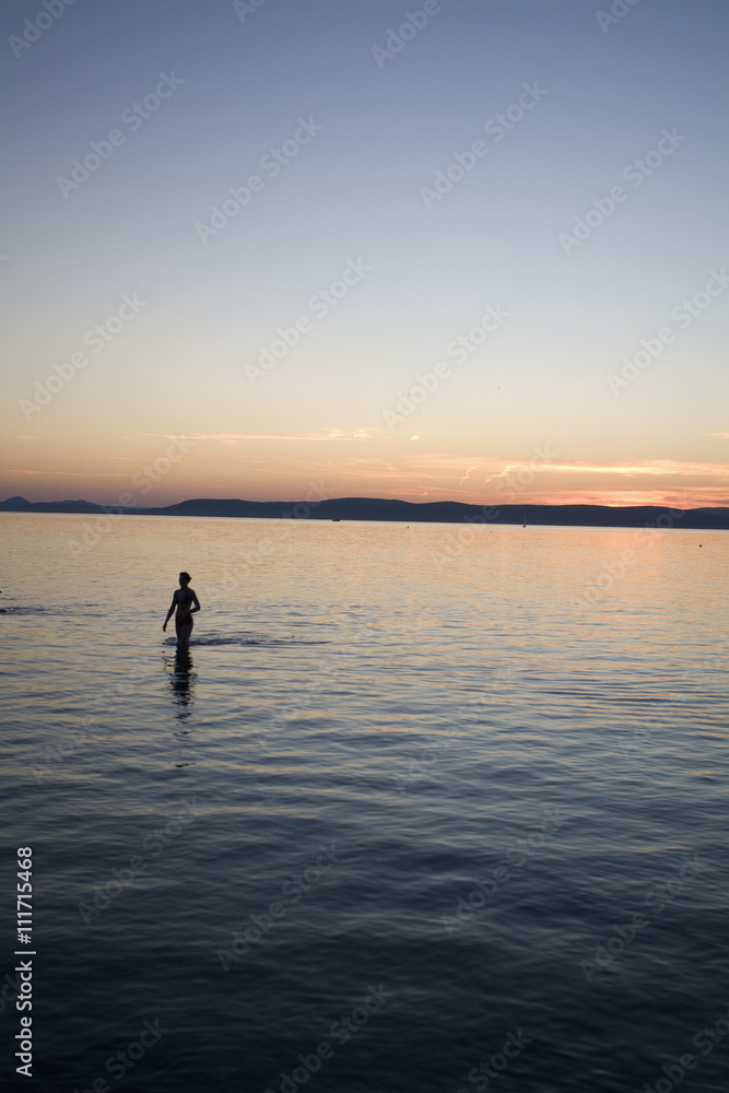 Silhouette of people bathing in a lake, Hungary. Silhouette of people bathing in a lake, Hungary.