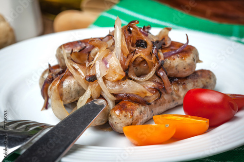 Fried Fried white sausages with onion on the plate.white sausage photo