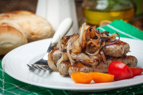 Fried Fried white sausages with onion on the plate.white sausage photo