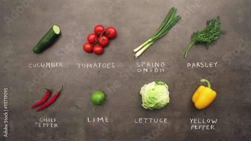 Multiple ingredients and vegetables with chalky signs changing on grey kitchen table. Flat lay recipe & food preparation concept. Stop motion animation.