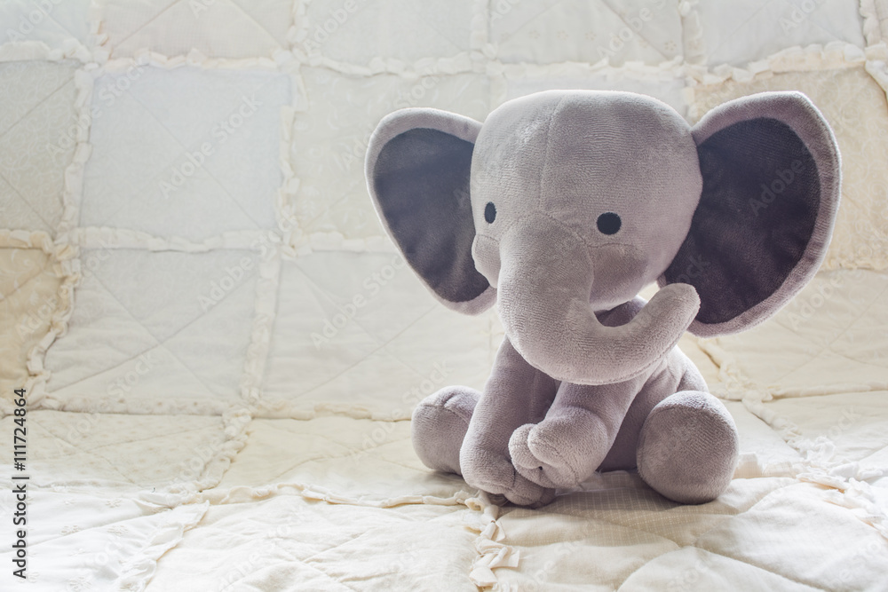 Cute Baby Elephant Stuffed Animal on a White Quilt Stock Photo | Adobe