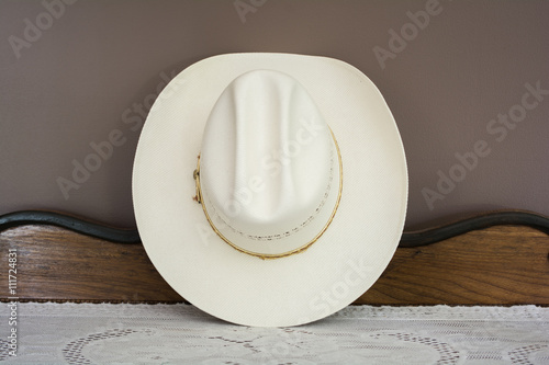 A White Cowboy Hat on an Antique Cabinet Front View