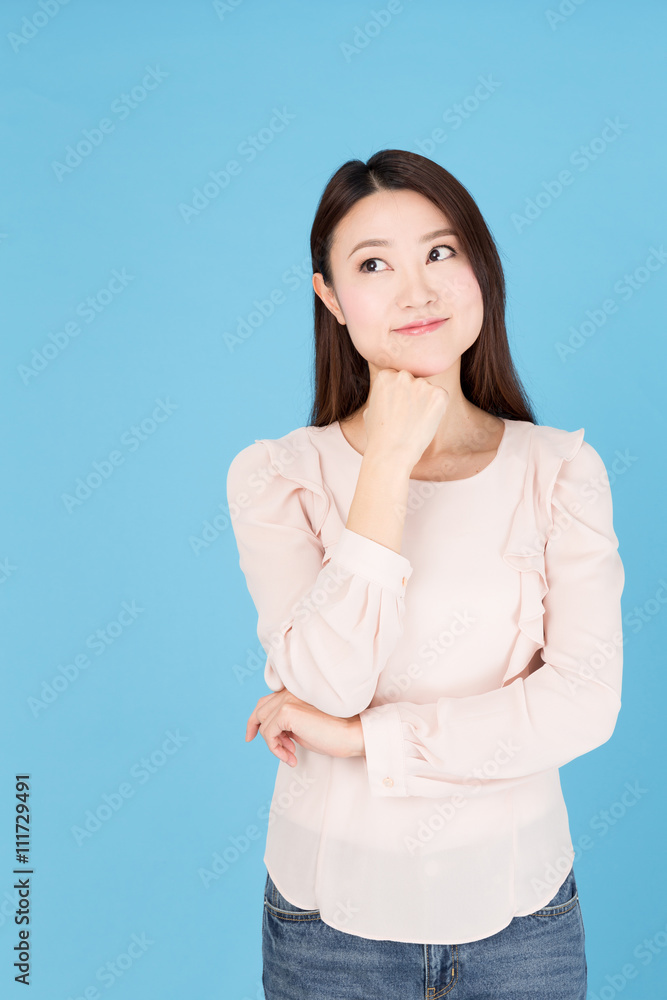portrait of asian woman thinking isolated on blue background portrait of asian woman thinking isolated on blue background