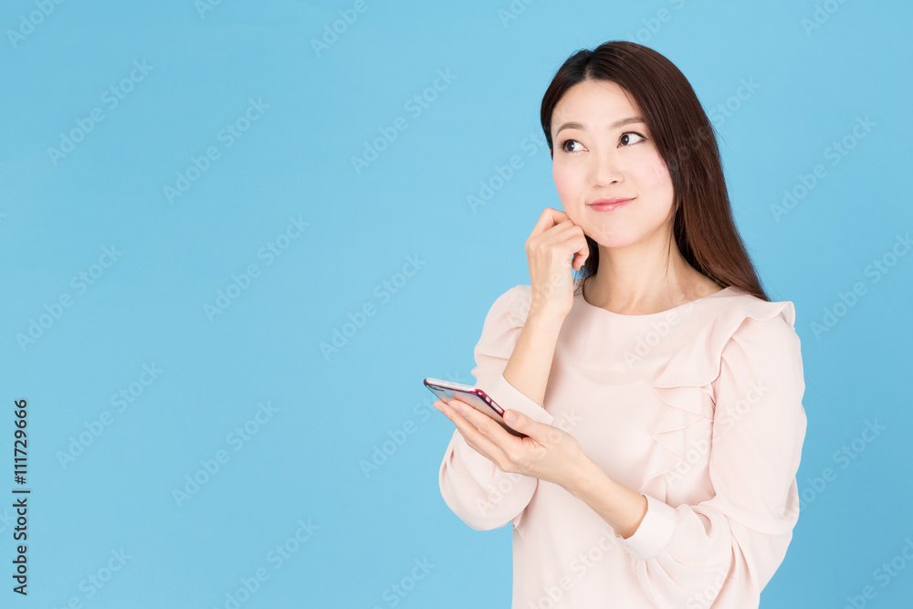 portrait of asian woman using smart phone isolated on blue background portrait of asian woman using smart phone isolated on blue background