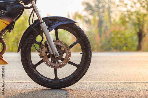Front wheel of motorbike on asphalt road