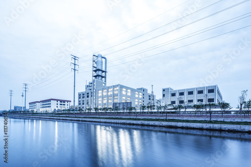 modern factory near river in cloud sky