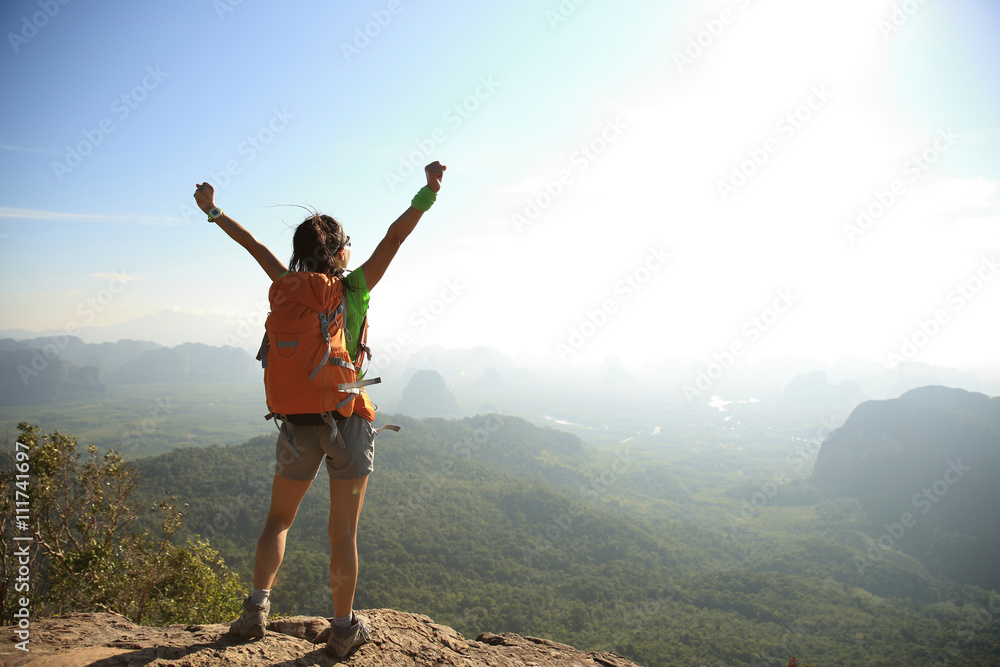 cheering woman hiker at sunrise mountain peak cheering woman hiker at sunrise mountain peak