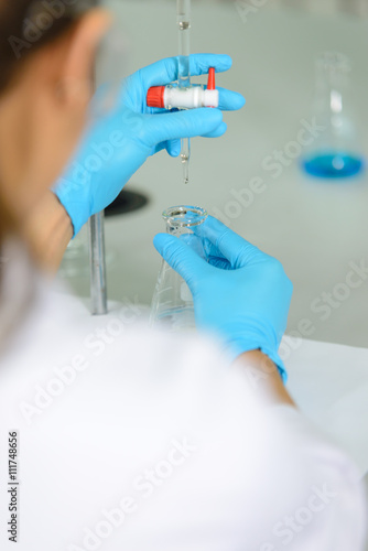The woman who’s the scientist is demonstrate the titration technician