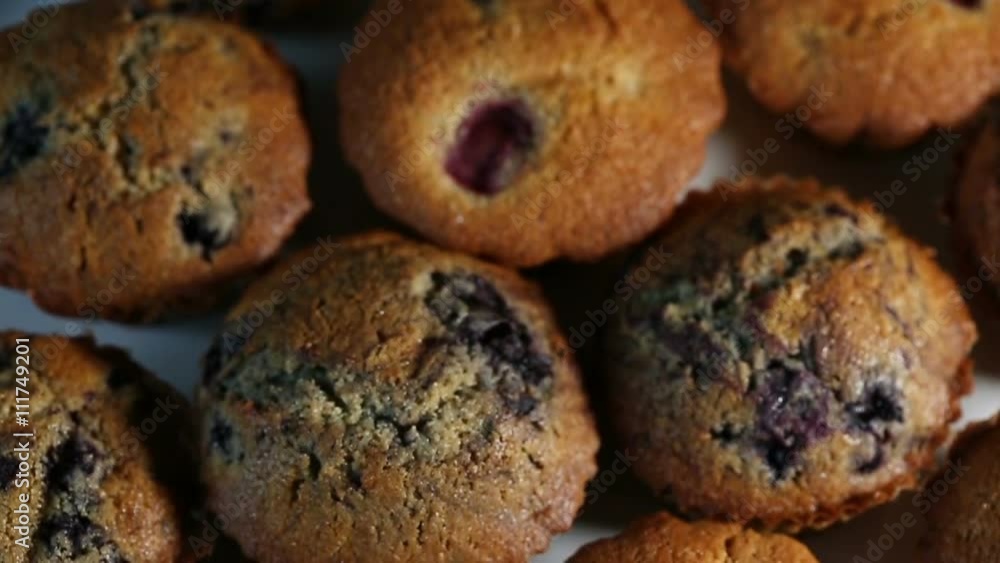 Homemade wholegrain muffins with berries on a white plate. Slow motion Homemade wholegrain muffins with berries on a white plate. Slow motion