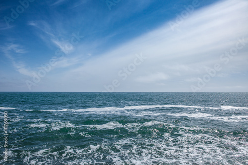 Blue sea with waves and sky with clouds