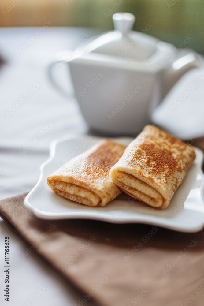 pancakes stuffed with tea and breakfast on a gray fabric background white dishes pancakes stuffed with tea and breakfast on a gray fabric background white dishes