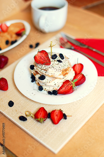 studio photo of breakfast table, sweet pancakes with summer berries 