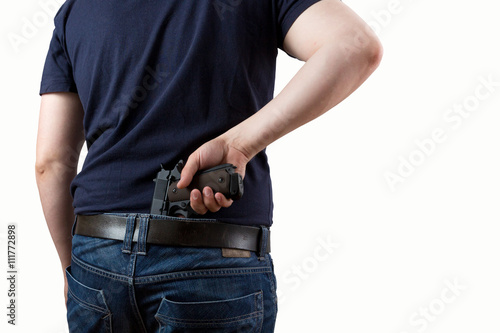 Mann zieht Pistole aus der Hose isoliert auf weißem Hintergrund