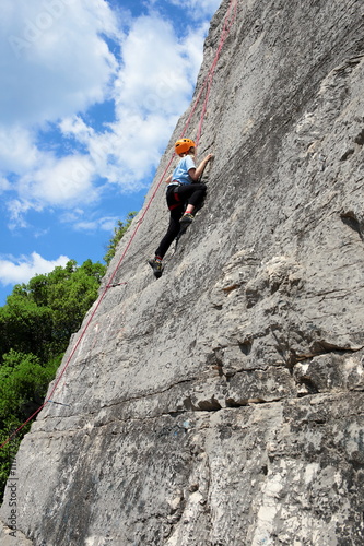Mädchen klettert an Felswand