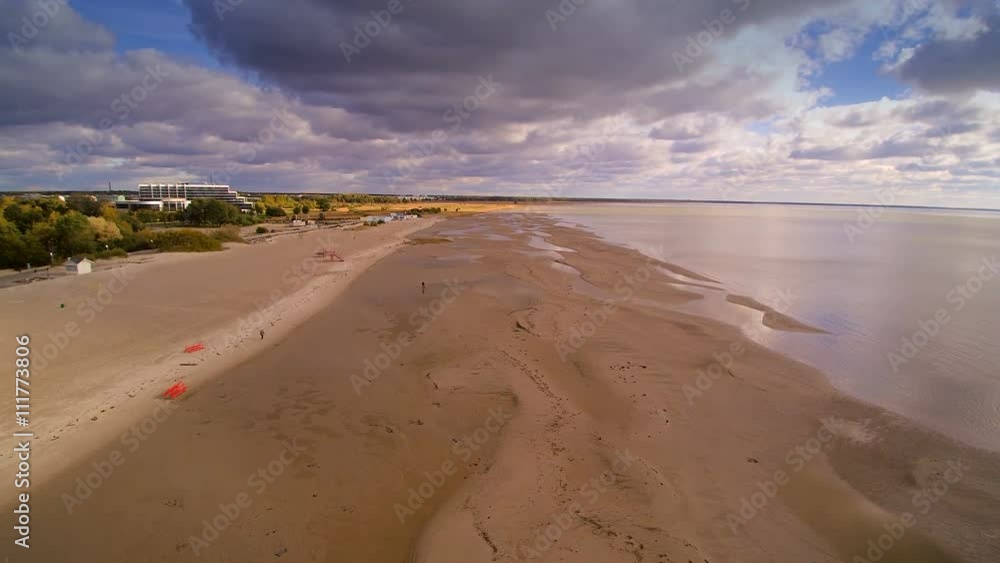 The white coastal sand of Parnu beach where tourists and visitors enjoy their summer vacation on the beach with their families The white coastal sand of Parnu beach where tourists and visitors enjoy their summer vacation on the beach with their families