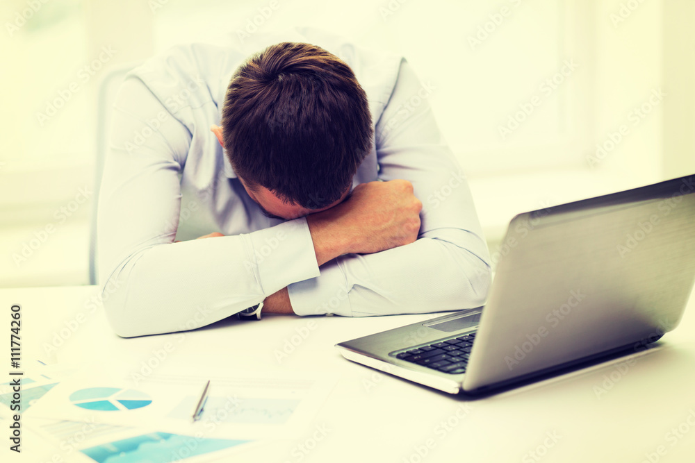 businessman with laptop and papers in office businessman with laptop and papers in office