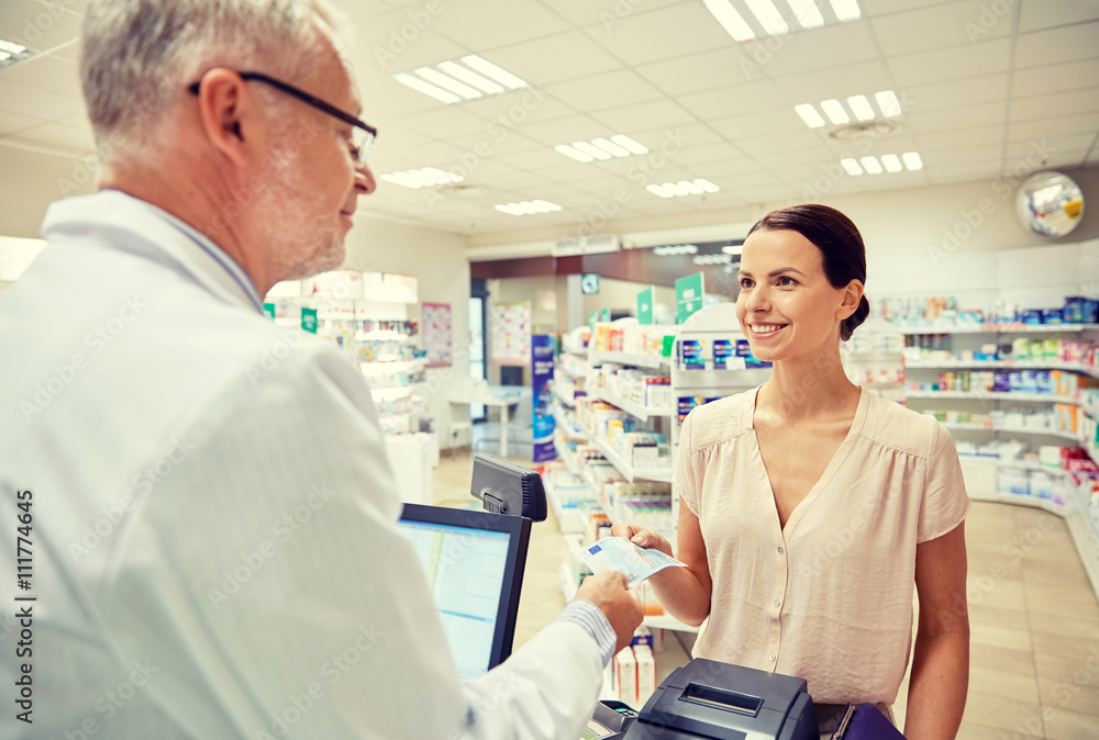 woman giving money to pharmacist at drugstore woman giving money to pharmacist at drugstore
